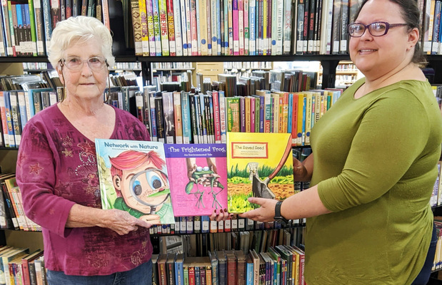 NEW BOOKS
Three new books were recently presented to the Garland Smith Public Library and the Central High School Library by members of Marlow Patio Garden Club. Mrs. Bettie Cooper, president of the club, presents Lacy Burch, children’s librarian at Marlow, with the books: Network with Nature, The Frightened Frog and The Saved Seed.