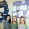 BALLOON SUCCESS: Marlow Elementary School students Keira Blundell, Olive Bell, and Riley Gaskins stand beside displays of letters and photos of people in Michigan, Missouri, and Massachusetts who wrote letters to the kindergarteners after finding balloons they released on the 100th day of school.