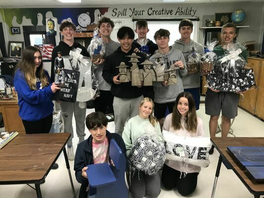 MHS art students show some of the gift baskets that will be auctioned off at the second annual Art Auction on March 31. Also on offer are art pieces created by students as well as several local artists.