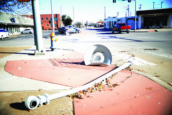 Street lights at 10th and Walnut were ripped and tossed to the ground, leaving huge chunks of thick glass debris on the street, sidewalks and parking lots. A gas pump was also knocked to the ground as seen in the background to the right. This area is one block north of Main Street. One block to the west of this intersection, a roof was ripped off a large building. Damage like this could be seen on nearly every street for the surrounding area. Photo by Toni Hopper/The Marlow Review