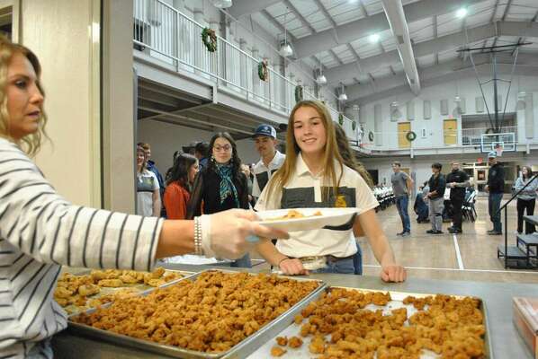 Marlow High School FFA officer, Kennedy Kizarr, waits for her dish to be filled before the auction begins, Thursday, Dec. 1, 2022. Photo by Toni Hopper/The Marlow Review