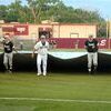 DELAY OF GAME: Marlow and Beggs players work together to remove the tarp at Edmond Memorial High School before their Class 3A State Tournament game last Thursday. The game was delayed by 2 1/2 hours, and was not completed until just before midnight.
