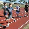PASSING THE BATON: Marlow boys track team members practice handing off the baton for relay races Tuesday afternoon.