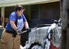 Jamie Fitch works to open the pickup truck hood on her first day as a firefighter. The temperatures were over 100 degrees on July 13, 2023. The truck was a total loss. 
 Photos by Toni Hopper/The Marlow Review