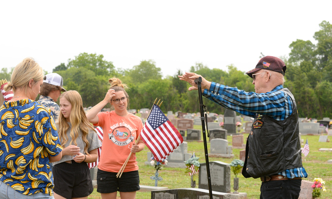 Vietnam veteran Earl Lavey of Marlow give just a few instructions to Tamela Heaton and the group of youngsters who came to the Marlow Cemetery on Saturday, May 27, 2023, to add new flags to the graves of service members buried there. Photo by Toni Hopper/The Marlow Review