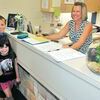 GETTING CLOSE: Jayden and Chevi-Lyn Rush were at Marlow Elementary School along with their mother to enroll for classes at Marlow Elementary School as MES secretary Leigh Throckmorton helps out on Tuesday morning. Classes begin at Marlow on Aug. 10.